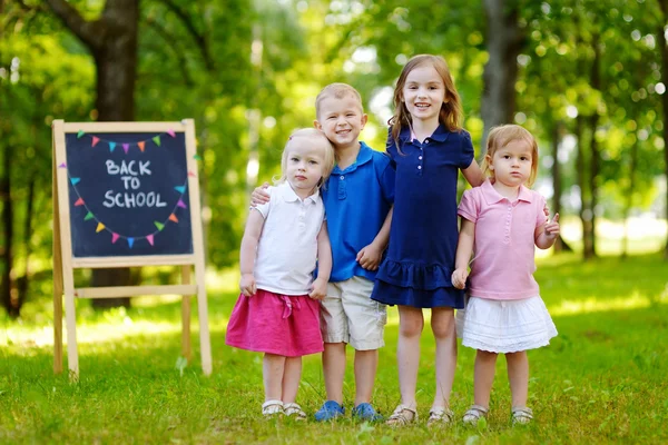 Four little kids by chalkboard — Stock Photo, Image