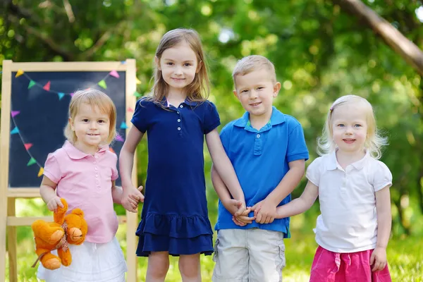 Cuatro niños pequeños en pizarra — Foto de Stock