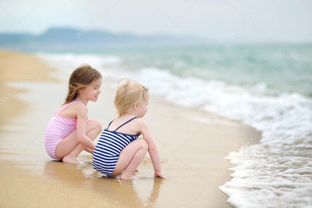 Two little sisters  on   beach