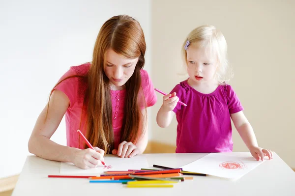 Девушка и мать рисуют карандашами — стоковое фото
