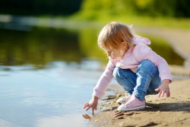 niña jugando por río