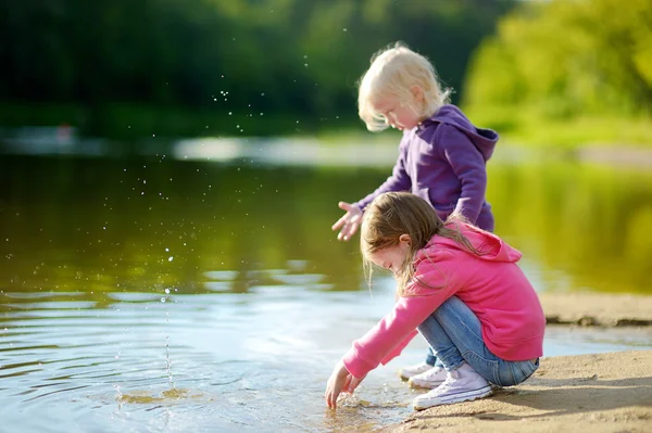 Little sisters nehir kenarında oynarken — Stok fotoğraf