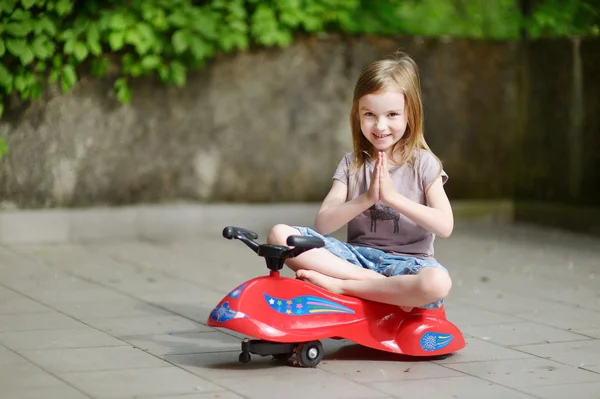 Mädchen fährt Spielzeugauto — Stockfoto