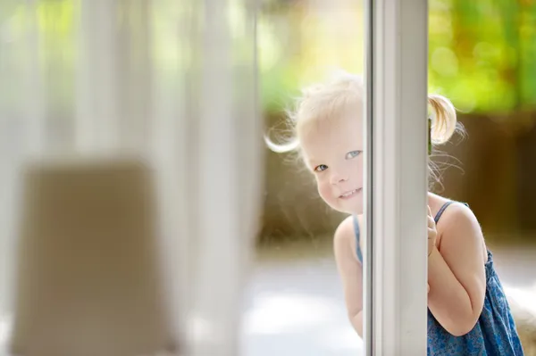 Девушка заглядывает в окно — стоковое фото