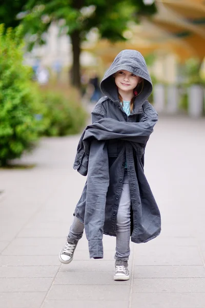 Девушка в пальто своего отца — стоковое фото