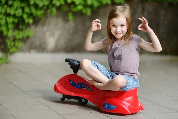 Девушка за рулем игрушечной машины — стоковое фото