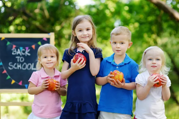 Four little kids by chalkboard — Stock Photo, Image