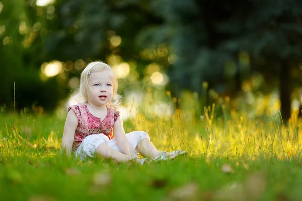 Petite fille assise sur l'herbe — Photo