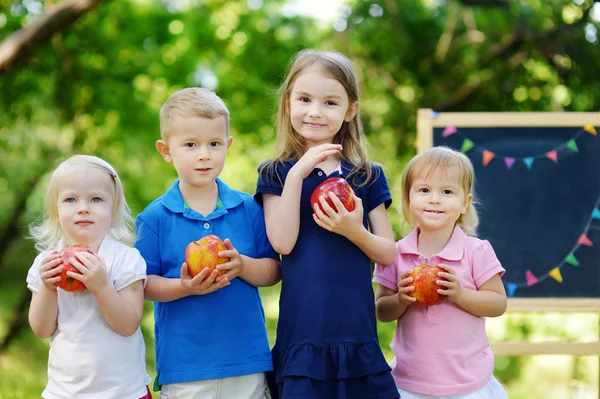 Four little kids by chalkboard — Stock Photo, Image