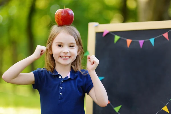 Little schoolgirl by   chalkboard — Stock Photo, Image