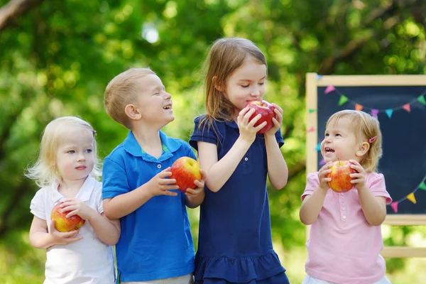 Four little kids by chalkboard — Stock Photo, Image