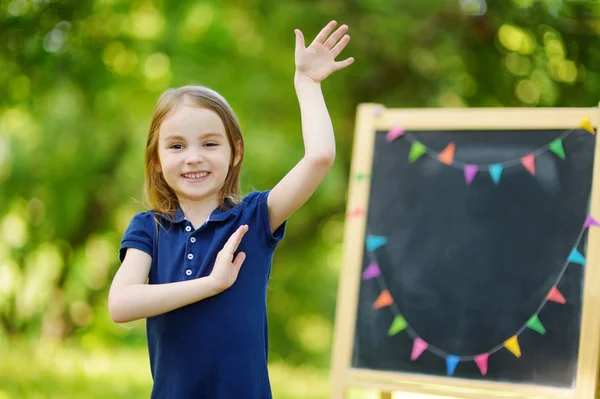 Little schoolgirl by   chalkboard — Stock Photo, Image