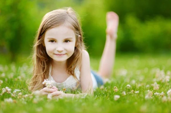 Маленькая девочка, лежащая в траве — стоковое фото