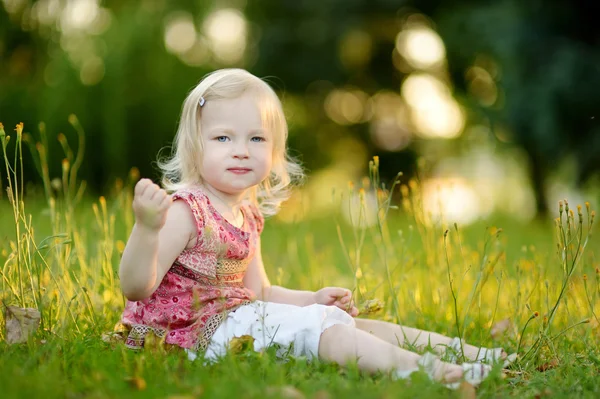 Niña sentada en la hierba — Foto de Stock