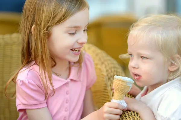 Two little sisters eating ice cream — Stock Photo, Image