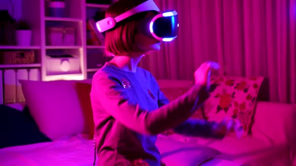 Pěkný dospívající dívka na sobě virtuální realita sluchátka v tmavé místnosti — Stock video