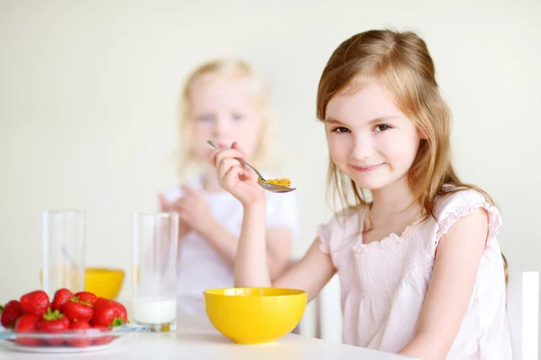 Systrar äta flingor med mjölk — Stockfoto