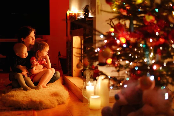 Madre e hijas cerca de la chimenea —  Fotos de Stock