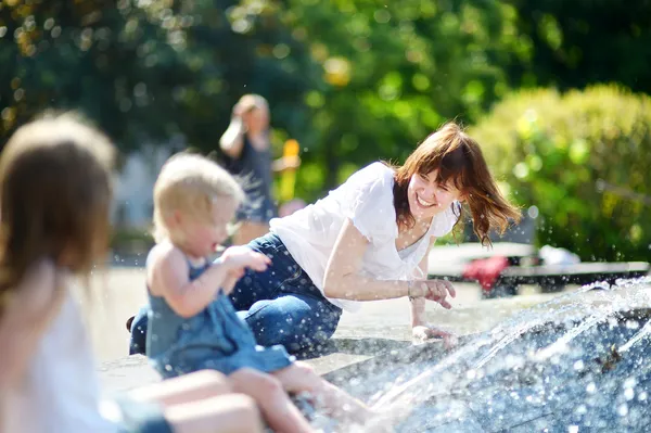 Woman and two kids by fountain — Stock Photo, Image