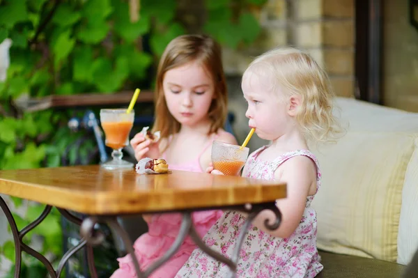 Sisters drinking juice — Stock Photo, Image