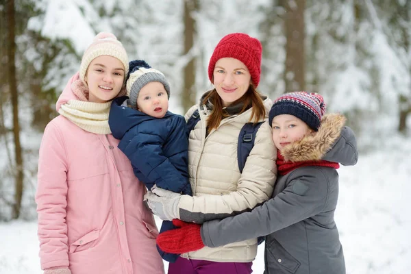 年轻的母亲和她的三个孩子在户外玩得很开心 两个年轻的女孩和她们的男婴在冬日结成姐妹 年龄差距大的儿童 孩子们一起探索大自然 — 图库照片