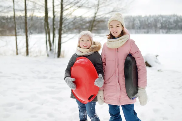 Две Забавные Девушки Веселятся Санями Красивом Зимнем Парке Милые Дети — стоковое фото