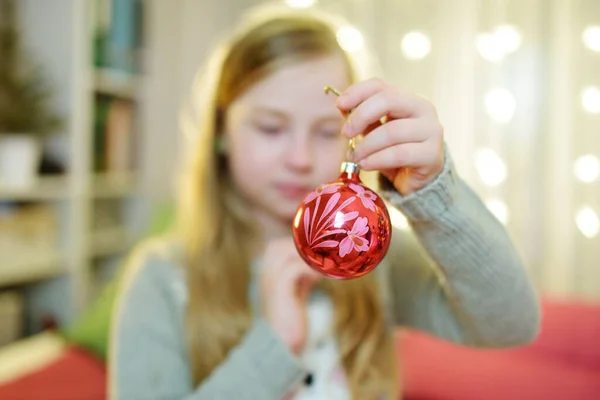 カラフルなガラスの泡でクリスマスツリーを飾る愛らしい若い女の子 クリスマスツリーをトリミングします 自宅でクリスマスを祝う — ストック写真