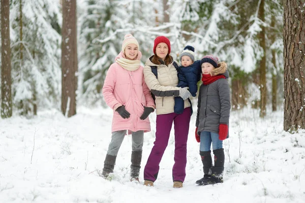 年轻的母亲和她的三个孩子在户外玩得很开心 两个年轻的女孩和她们的男婴在冬日结成姐妹 年龄差距大的儿童 孩子们一起探索大自然 — 图库照片