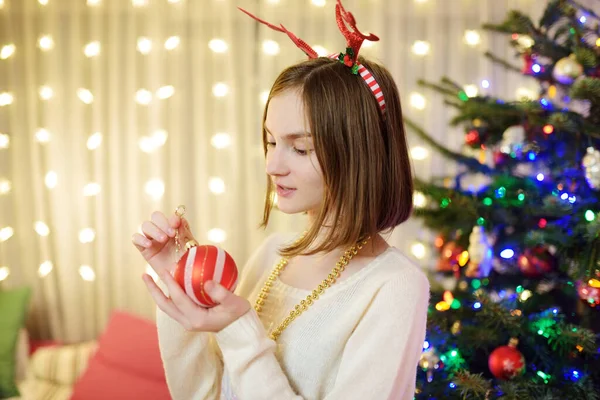 カラフルなガラスの泡でクリスマスツリーを飾る愛らしい若い女の子 クリスマスツリーをトリミングします 自宅でクリスマスを祝う — ストック写真