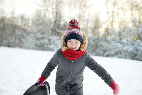 雪の中で美しい冬の公園で楽しんでいる愛らしい若い女の子 雪の中で遊ぶかわいい子供 子供連れの家族のための冬の活動 — ストック写真