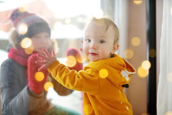 Imádnivaló Kisfiú Áll Ablaknál Napsütéses Karácsony Napján Toddler Játszik Húgával — Stock Fotó