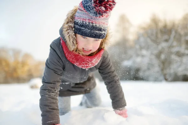 雪の中で美しい冬の公園で楽しんでいる愛らしい若い女の子 雪の中で遊ぶかわいい子供 子供連れの家族のための冬の活動 — ストック写真