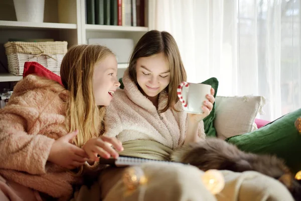 Two Young Sisters Snuggling Sofa Cozy Living Room Christmas Cute — Stock Photo, Image