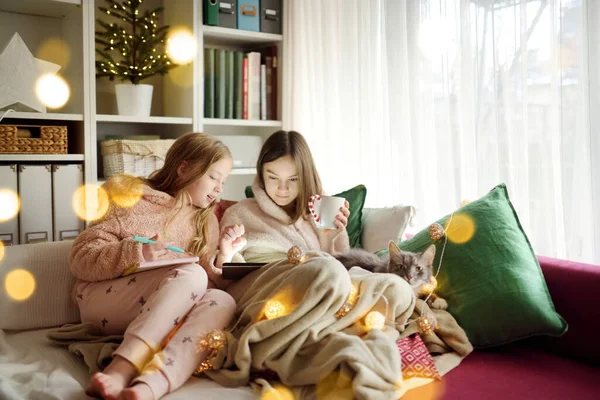 Two Young Sisters Snuggling Sofa Cozy Living Room Christmas Cute — Stock Photo, Image