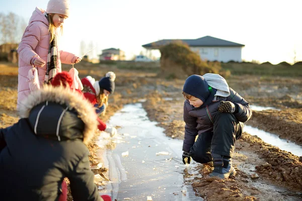 一群孩子在冻土上玩着薄冰布丁 孩子们在冬天玩得很开心 儿童冬季活动 — 图库照片