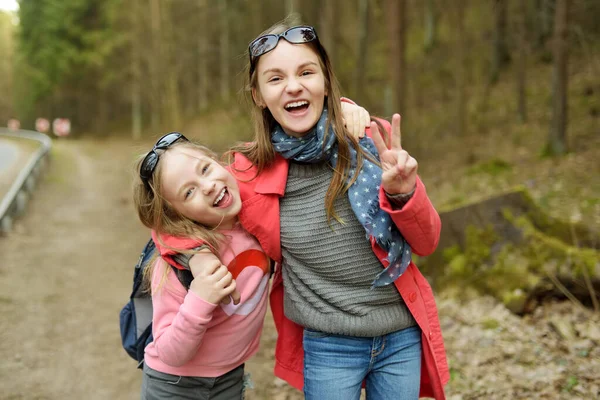 森の中に楽しいかわいい若い姉妹は 美しい春の日にハイキングします 子供とアクティブなファミリー向けのレジャーです 家族で楽しむ — ストック写真