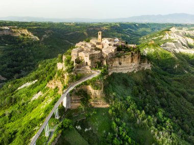 Tiber nehri vadisine bakan volkanik bir tuff tepesinin tepesinde yer alan ünlü Civita di Bagnoregio köyünün hava manzarası. Bu yerin Etrüsk ve Ortaçağ kökenleri var..