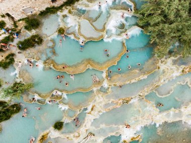 Terme di Saturnia 'nın havadan görünüşü, jeotermal sülfür yayları ve Saturnia termal banyolarında şelaleli doğal spa. Cascate del Mulino, Grosseto, Toskana, İtalya.