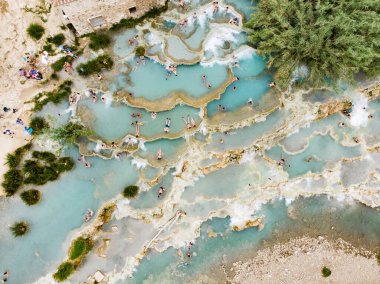 Terme di Saturnia 'nın havadan görünüşü, jeotermal sülfür yayları ve Saturnia termal banyolarında şelaleli doğal spa. Cascate del Mulino, Grosseto, Toskana, İtalya.