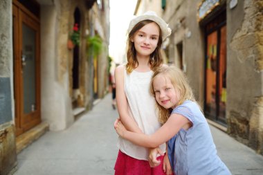 Küçük Kudüs olarak bilinen volkanik tufa sırtı üzerinde bulunan ünlü Pitigliano kasabasını keşfeden genç kızlar. Güzel İtalyan kasabaları ve köyleri. Etrüsk mirası, Grosseto, Toskana, İtalya.
