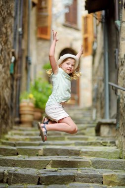 İtalya 'nın en büyük gölü olan Lago Bolsena' nın kıyısındaki Bolsena tatil beldesinin ortaçağ sokaklarını keşfeden genç bir kız..