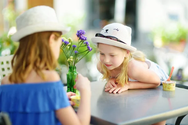 在意大利翁布里亚的奥尔维托 两个妹妹在家庭度假期间 在温暖和阳光灿烂的夏日吃着冰淇淋 可爱的孩子们坐在户外咖啡店里 吃着糊状的东西 — 图库照片