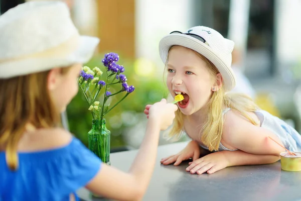 在意大利翁布里亚的奥尔维托 两个妹妹在家庭度假期间 在温暖和阳光灿烂的夏日吃着冰淇淋 可爱的孩子们坐在户外咖啡店里 吃着糊状的东西 — 图库照片