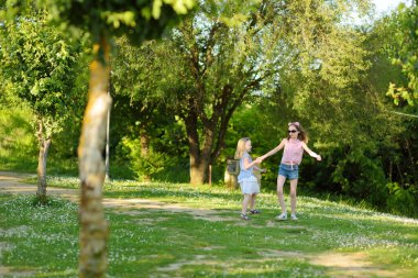 Bagno Vignoni 'deki doğal yüzme havuzunda oynayan iki genç kız kardeş, termal kaynak suyu ve beyaz beton ve şelale oluşturan kalsiyum karbonat yataklarıyla. Toskana, İtalya.