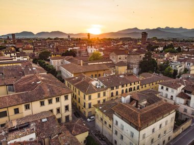 El değmemiş Rönesans dönemi şehir duvarları ve iyi korunmuş tarihi merkeziyle ünlü Lucca şehrinin hava günbatımı manzarası. Lucca ili, Toskana, İtalya.