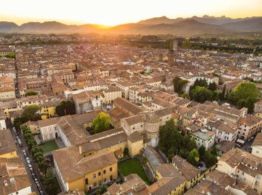 El değmemiş Rönesans dönemi şehir duvarları ve iyi korunmuş tarihi merkeziyle ünlü Lucca şehrinin hava günbatımı manzarası. Lucca ili, Toskana, İtalya.