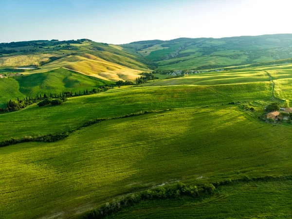 地平線に小さな村と緑のフィールドや農地の見事な空中ビュー 丘陵の夏の農村風景 トスカーナの湾曲した道路やヒノキ イタリア — ストック写真