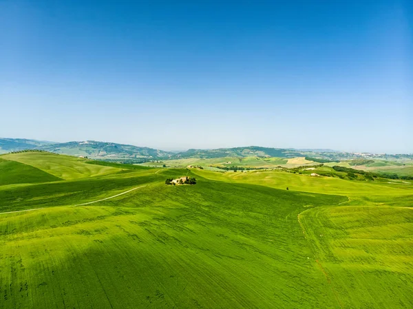 地平線に小さな村と緑のフィールドや農地の見事な空中ビュー 丘陵の夏の農村風景 トスカーナの湾曲した道路やヒノキ イタリア — ストック写真