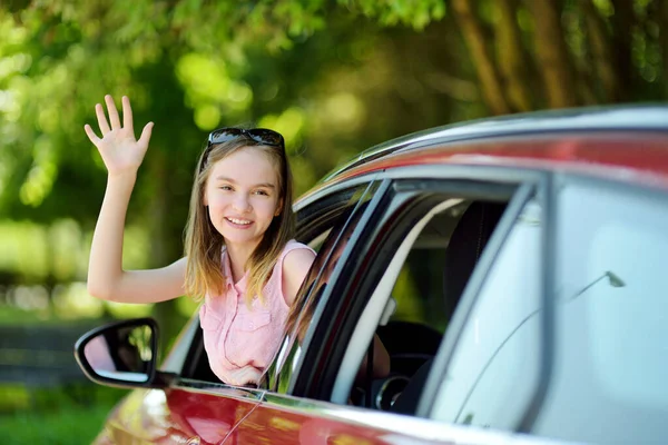 面白い若い女の子が前方のロードトリップや旅行を探して車の窓の外に彼女の頭を固執する 子供と家族の車旅行 — ストック写真