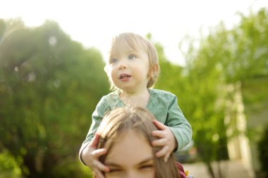 Şirin ablasının küçük kardeşiyle kucaklaşması. Sevimli genç kız kucağında erkek bebek. Geniş yaş farkı olan çocuklar. Kardeşler arasında büyük yaş farkı var. Büyük aile..
